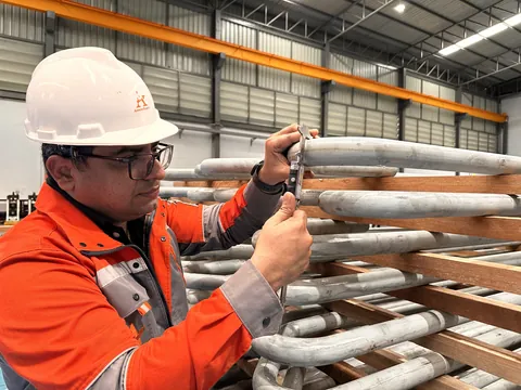 Arrow Energy engineer checking formed tube bend dimensions with a vernier caliper